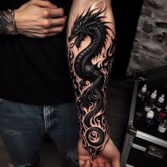 a man with a black dragon tattoo on his arm and hand is holding another person's hand