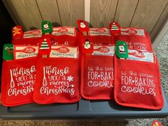 red christmas stockings with writing on them sitting on a shelf in front of a door