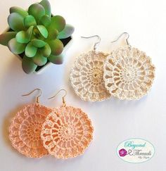 three pairs of crochet doily earrings next to a succulent plant