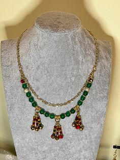 Green agate festive necklace with beaded charms. Charms are multi color crystal glass with red snd gold accents. Gold colored stainless steel chain with rhinestone bead accents. Great for holiday parties, Christmas and weddings Necklace With Charms, Beaded Charms, Festival Necklace, Green Agate, Rhinestone Bead, Color Crystal, Red And Gold, Steel Chain, Stainless Steel Chain