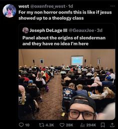 a man with glasses is standing in front of a room full of people