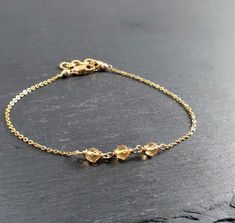 This beautiful handmade bracelet features 3 Genuine Golden Citrine gemstones wrapped in the metal of your choice. Dainty, minimal, and elegant, this bracelet is the perfect finishing touch to any style or event. Makes a great gift to add to any gemstone lover's collection. Perfect to gift for Christmas, Valentine's Day, Mother's Day, and more! Gemstone: Citrine Gemstone Size: 3.0 mm Gemstone Color: Golden Yellow Gemstone Shape: Rondelle, Faceted Metal: 14k Gold Filled or Sterling Silver (Nickel Citrine Bracelet, Yellow Gemstones, Citrine Gemstone, Gift For Christmas, Handmade Bracelet, Golden Yellow, Diy Bracelets, Gemstone Colors, Beautiful Bracelet