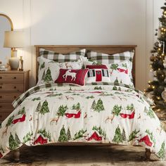 a bed covered in christmas themed sheets and pillows