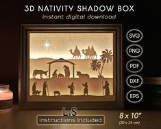 the nativity shadow box is displayed next to a lit candle