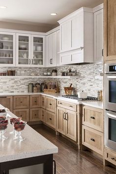 a kitchen filled with lots of white cabinets and counter top space next to an oven