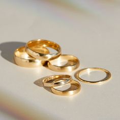 three gold wedding rings sitting next to each other