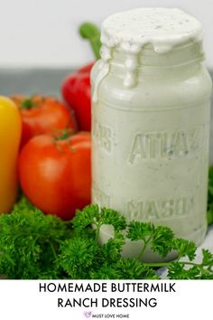 a jar of homemade buttermik ranch dressing next to some fresh tomatoes and peppers