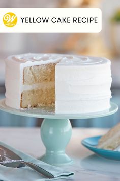 a white cake sitting on top of a table with a slice missing from it's side