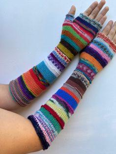 two hands with colorful knitted gloves on them