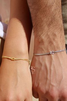 two people are holding hands and wearing bracelets with the word love written on them