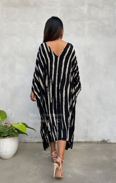 This kaftan complements all body types with its long, loose design and slits up both sides. The unique pattern is created by using a discharge dye process to remove color. I use a high quality rayon voile fabric that both flows and drapes around you. The eco printed kaftan can be worn in many stylish ways to make you look your best. DETAIL * All measurements are flat * Bust/ Waist/ Hips 34 in (Circumference 68 in.) * Arms 11 in. (Circumference 22 in.) * Length 42 in. * V-Neck * Side slits * No p Black Long Kaftan For Beach Season, Long Black Kaftan For Beach Season, Black V-neck Tunic For Vacation, Printed Black Kaftan For Beach, Black Printed Tunic Kaftan, Black Printed Kaftan For The Beach, Black Beach Maxi Dress With Kimono Sleeves, Black Flowy Summer Kaftan, Free Size Black Kaftan For Beachwear