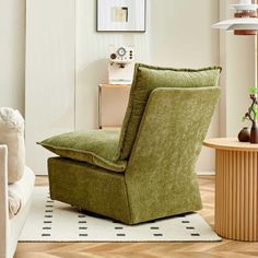 a green chair sitting on top of a hard wood floor next to a white rug