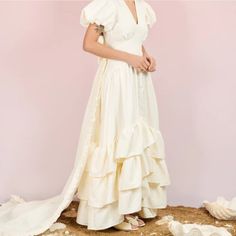 a woman in a white dress standing on a pile of shells wearing a headband