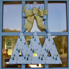 a christmas tree made out of cardboard with a bow on it's front door