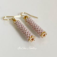 pair of pink and gold beaded earrings on white background