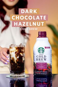 a woman is holding a cold beverage next to a glass full of cold brew coffee