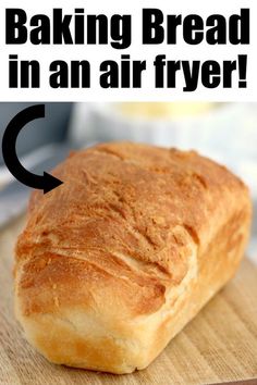 a loaf of bread sitting on top of a wooden cutting board with the words baking bread in an air fryer