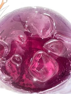 a glass filled with ice and water on top of a table