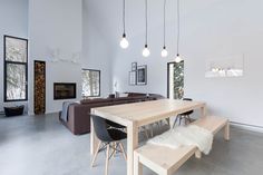 a dining table and bench in a room with white walls, flooring and large windows