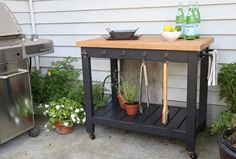 a wooden table sitting on top of a patio next to potted plants and flowers