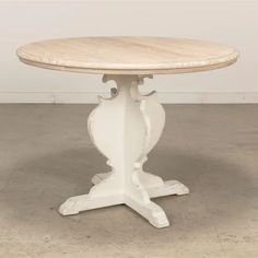 a white table with a wooden top on concrete floored area in front of wall