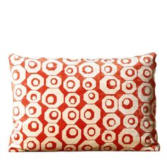 an orange and white pillow with circles on it's side, against a white background