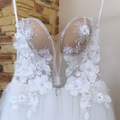 the back of a wedding dress with flowers on it