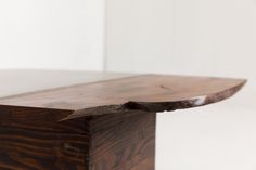 a close up of a wooden table with white walls in the backgroung