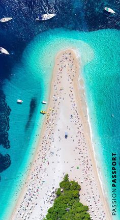 an aerial view of a beach with boats in the water