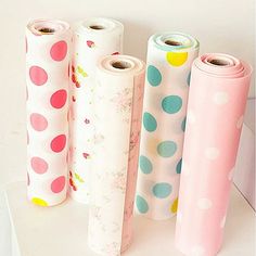 four rolls of wrapping paper sitting next to each other on top of a white counter