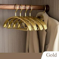 gold clothes hangers are hanging on a coat rack