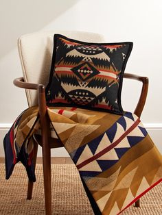 a chair with a blanket on top of it next to a white wall and floor