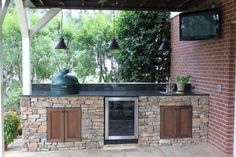 an outdoor kitchen with stone counter tops and cabinets