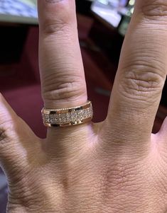 a person's hand with a gold ring on top of it and two diamonds in the middle