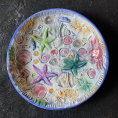 a plate with sea shells and starfishs painted on it