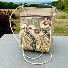 "A sweet  little bag specially made for all times where you need to have your phone(even the largest will fit)and a few other essentials . An excellent travel bag-it's flat and fits close to your body while leaving your hands free. Great for shopping,dancing or carrying a baby on your arm. Chenille Tapestry imported from Turkey combined with Cream Color Leather. A long adjustable Leather Strap. 6 \"Zipper Top opens to 1 large section with a small pocket that could hold a few credit card, plus a Portable Square Beige Phone Bag, Square Phone Bag With Removable Pouch For Daily Use, Beige Shoulder Bag With Zipper Pouch For On-the-go, Beige Square Phone Bag With Adjustable Strap, Square Phone Bag With Removable Pouch For Travel, Portable Shoulder Bag Pouch For Everyday Use, Beige Bags With Zipper Pouch For Everyday Use, Beige Bag With Zipper Pouch For Everyday Use, Beige Square Phone Bag With Removable Pouch