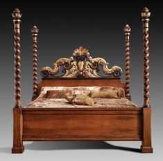 an ornate wooden bed with four posts and pillows on the headboard, in front of a gray background