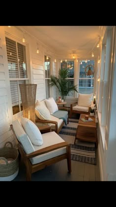 the porch is decorated with white furniture and string lights