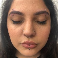 a woman with piercings on her nose