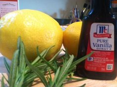 two lemons sitting on top of a wooden table next to a bottle of juice