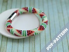 a white plate topped with a colorful bracelet