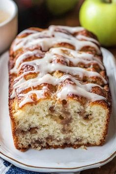 a loaf of cinnamon apple bread with icing on a plate next to an apple