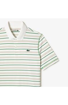 a white and green striped polo shirt with an alligator embroidered on the chest, in front of