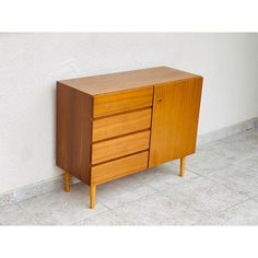 a wooden dresser sitting on top of a tiled floor