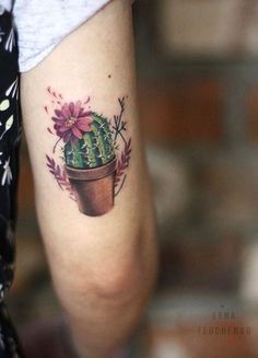 a small cactus tattoo on the arm