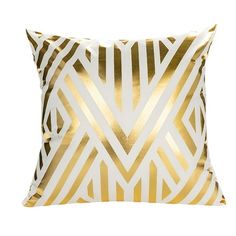 a gold and white pillow with an abstract design on the front, featuring diagonal stripes