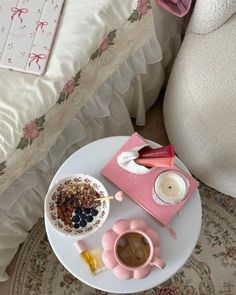 a table with some food on it next to a pillow and cup filled with coffee