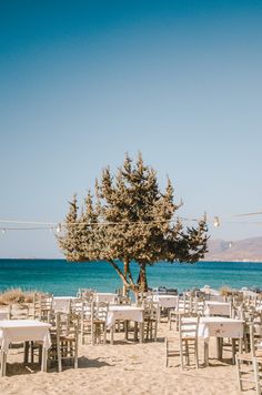 tables and chairs are set up on the beach