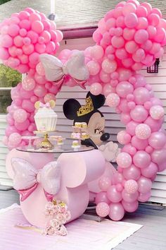 a minnie mouse balloon arch with pink balloons