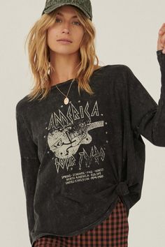 Mineral washed long-sleeve graphic t-shirt Vintage-style guitar graphic with "America Tour" text. Long drop-shoulder sleeves. Round neckline. Center back seam. Loose, oversized fit. 100% Cotton. Imported top designed and printed in Los Angeles, CA. Model wears size S. Graphic Tee With Long Sleeve Underneath, Long Sleeve Graphic Tees Outfit, Guitar Graphic, Long Sleeve Graphic Tees, Graphic Tee Outfits, Vintage Band Tees, Long Sleeve Tee Shirts, Vintage Band, Graphic Tee Shirts